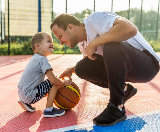 Família jogando no campo de basquete