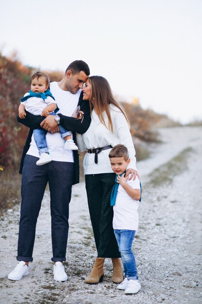 Família jovem com dois filhos juntos fora do parque