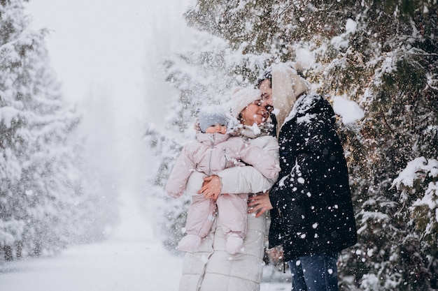 Família jovem com filha em uma floresta de inverno cheia de neve