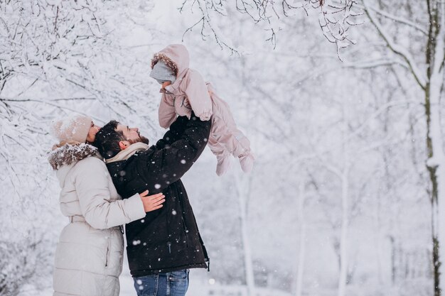 Família jovem com filha em uma floresta de inverno cheia de neve