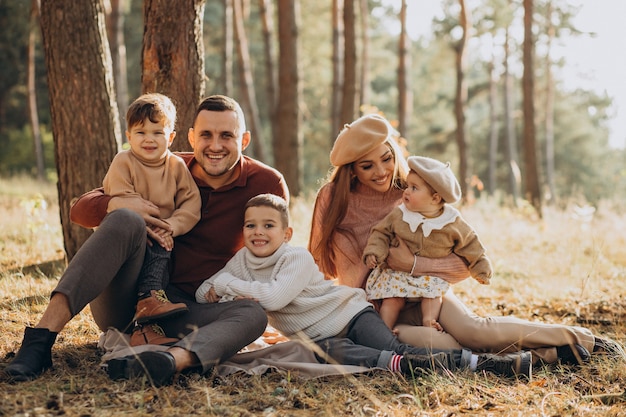 Família jovem com filhos fazendo piquenique no parque