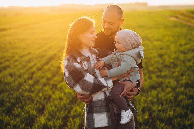 Família jovem com seus filhos se divertindo no campo