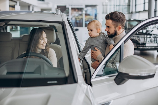 Família jovem com uma menina escolhendo um carro