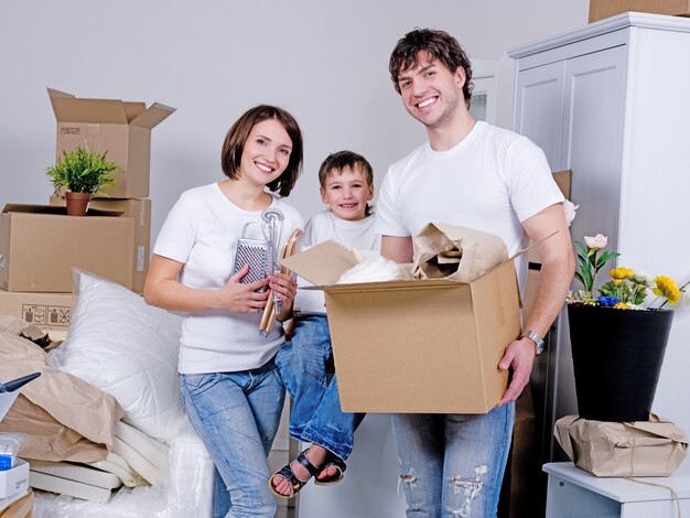 Família jovem e feliz mudando-se para o novo apartamento