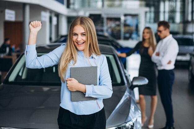 Família jovem, escolhendo um carro em uma sala de exposições