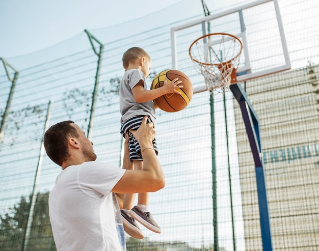 Família monoparental feliz jogando basquete