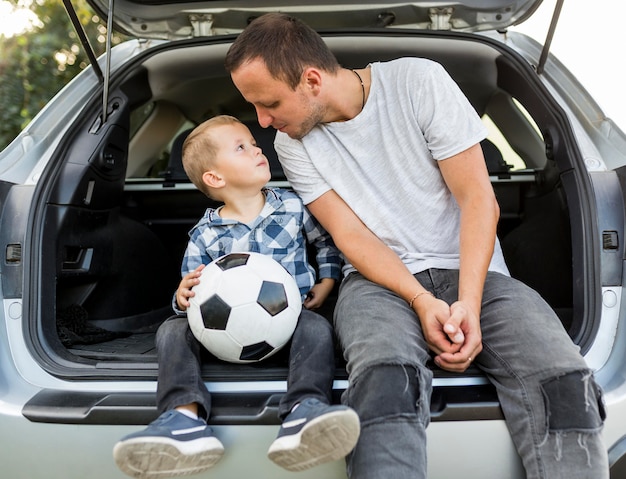 Família monoparental feliz sentada na parte de trás do carro