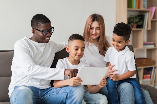 Família multicultural feliz se divertindo juntos em um laptop