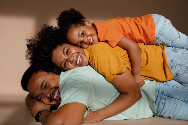 Família negra de tiro médio posando no estúdio