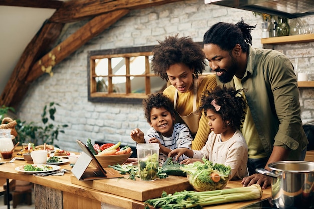 Família negra feliz preparando comida saudável na cozinha