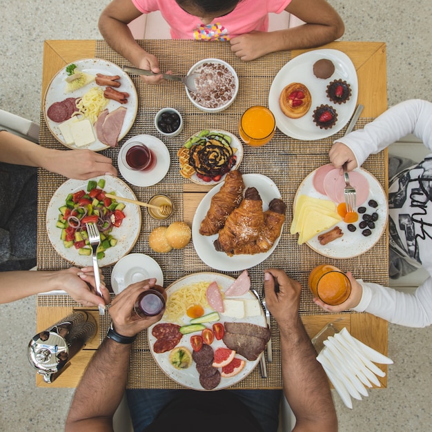 Família sentada arount mesa de café e comer