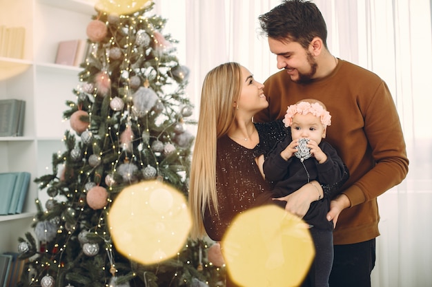 Família sentada em casa perto de árvore de natal