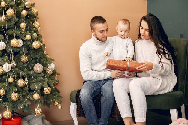 Família sentada em casa perto de árvore de Natal