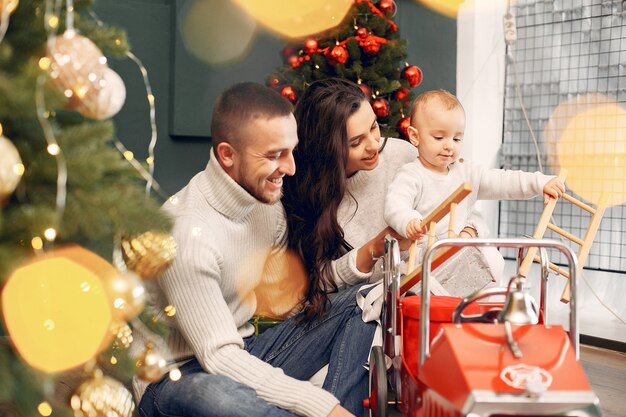 Família sentada em casa perto de árvore de Natal