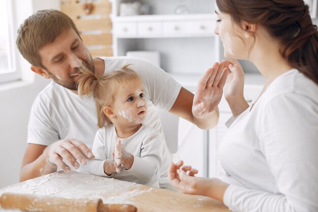 Família sentada em uma cozinha e cozinhar a massa para biscoitos