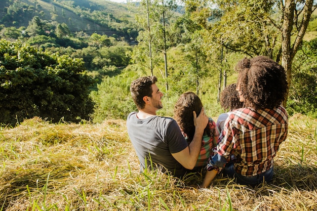 Foto grátis família sentada na vista do monte por trás