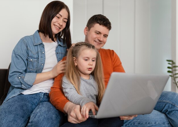 Família sorridente com foto média e laptop