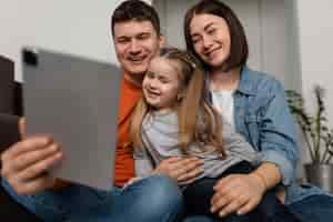 Foto grátis família sorridente com foto média e laptop