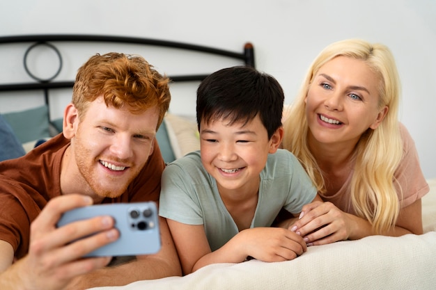 Família sorridente com foto média tirando selfie