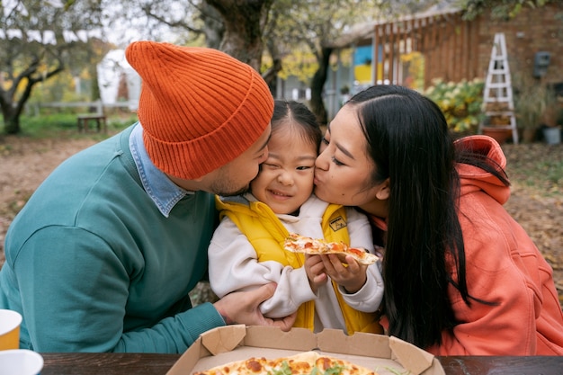 Foto grátis família sorridente com vista frontal de pizza