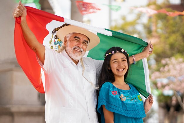 Família sorridente de vista lateral com bandeira mexicana