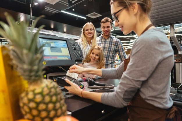 Família sorridente, pagando com cartão de crédito