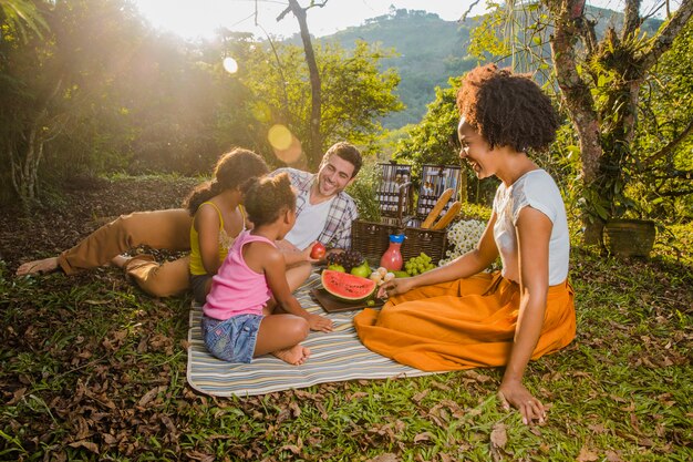 Família tendo um piquenique ao pôr do sol