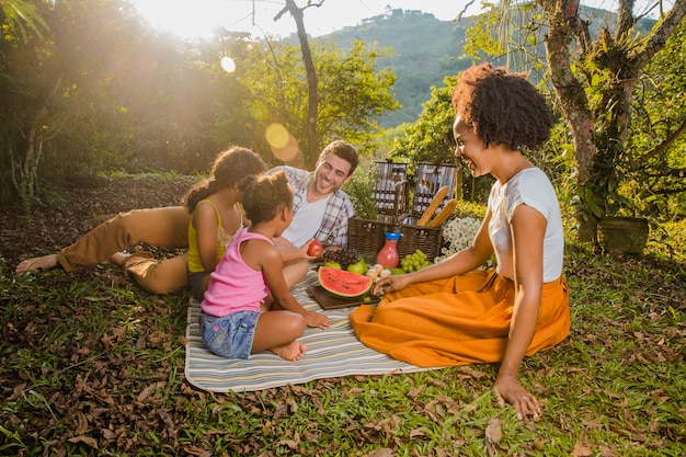 Família tendo um piquenique ao pôr do sol