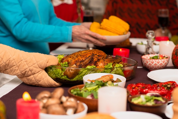 Foto grátis família trazendo comida na mesa de ação de graças