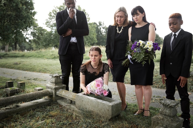 Família visitando o túmulo de um ente querido