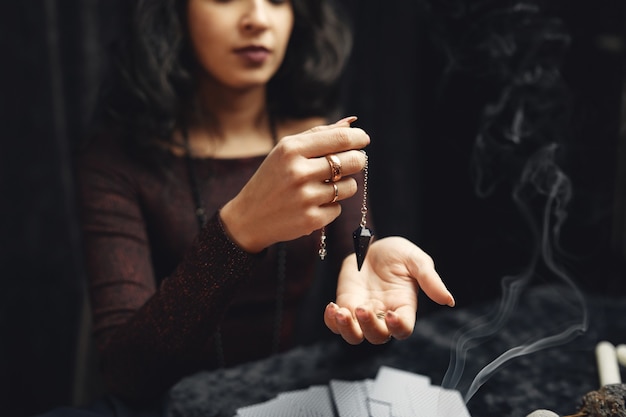 Foto grátis fantasia linda cigana. mulher cartomante lendo futuro em cartas de tarô mágico.