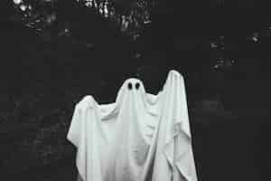 Foto grátis fantasma sombrio com mãos levantando em pé na floresta