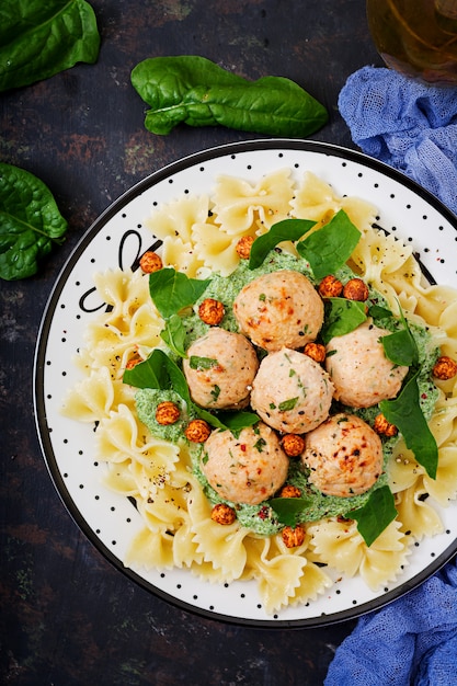 Farfalle macarrão com almôndegas e molho de espinafre com grão de bico frito.