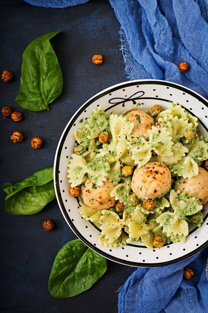 Farfalle macarrão com almôndegas e molho de espinafre com grão de bico frito.