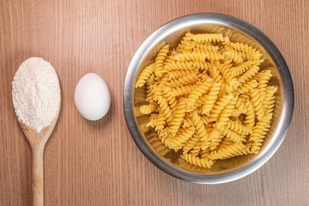 Foto grátis farinha de trigo, ovo e macarrão na mesa de madeira