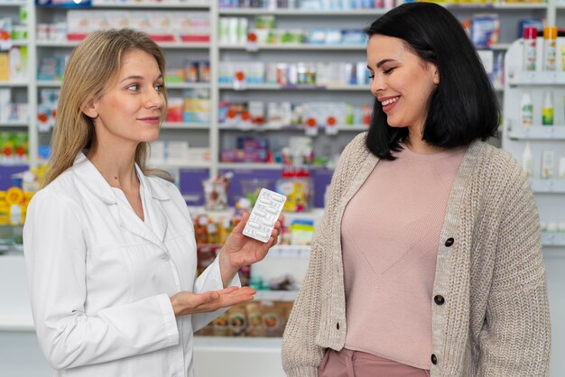 Farmacêutico de tiro médio ajudando paciente