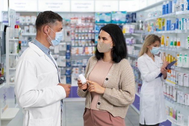 Farmacêutico de tiro médio ajudando paciente