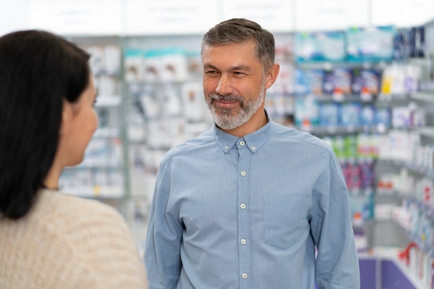 Foto grátis farmacêutico de vista frontal conversando com o paciente