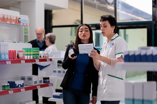 Foto grátis farmacêutico e cliente comparando caixas de vitaminas lendo instruções de uso