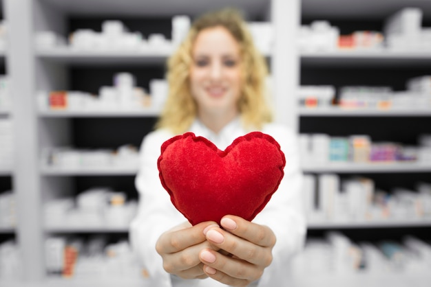 Farmacêutico em drogaria segurando coração