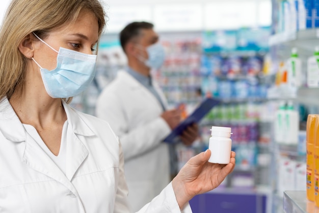 Farmacêuticos de tiro médio usando máscaras faciais
