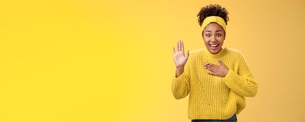 Foto grátis fascinada, divertida, jovem, encantadora, sincera, menina africana-americana, suéter de bandana, pressione a mão, levante o peito