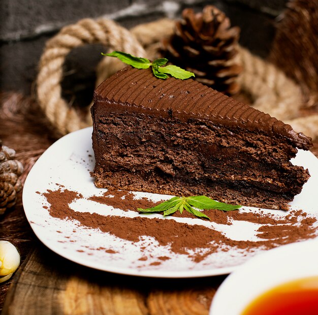 Fatia de bolo de chocolate cacau, servido com folhas de hortelã