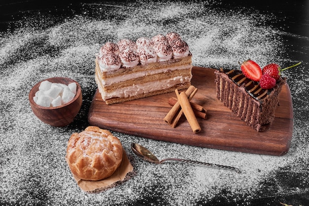 Fatia de bolo de chocolate com tiramisu em uma travessa de madeira.