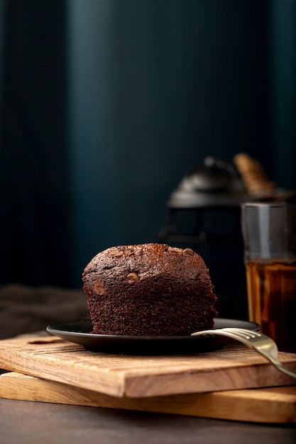 Fatia de bolo de chocolate em um suporte de madeira