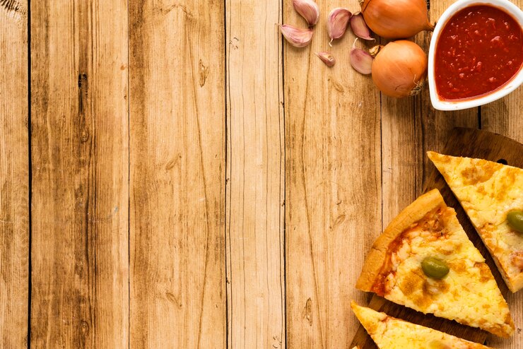 Foto grátis fatia de pizza e molho com ingrediente cru na superfície de madeira
