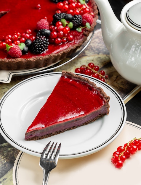 Foto grátis fatia de torta de berry servida ao lado de torta de queijo e bule