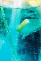 Foto grátis fatia fresca de limão que flutua no cocktail frio azul com bolhas