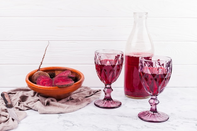 Foto grátis fatias de beterraba e suco vermelho em copos de vinho