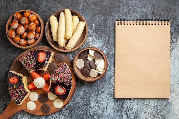 Fatias de bolo com nozes e biscoitos em superfície escura